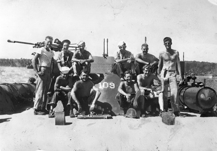 PC 100  Lt. (jg) John F. Kennedy (standing, far right) and crewmen of the PT 109. Solomon Islands, 1943. Photograph in the John F. Kennedy Presidential Library and Museum, Boston.